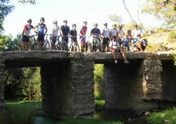 ciclistas em pose sobre uma ponte antiga no vale da Cabrela