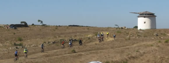 ciclistas a subir um trilho em direco a um moinho perto de Odrinhas