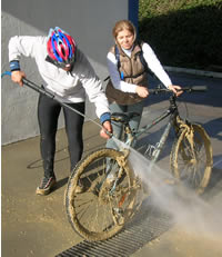 casal a lavar a bicicleta muito suja de lama