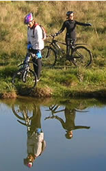 foto de 2 ciclista com reflexo na gua da lagoa