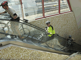 fotos de ciclista a utilizarem uma escada rolante com as bicicletas � m�o