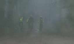 ciclista no meio do nevoeiro e da chuva perto do monge
